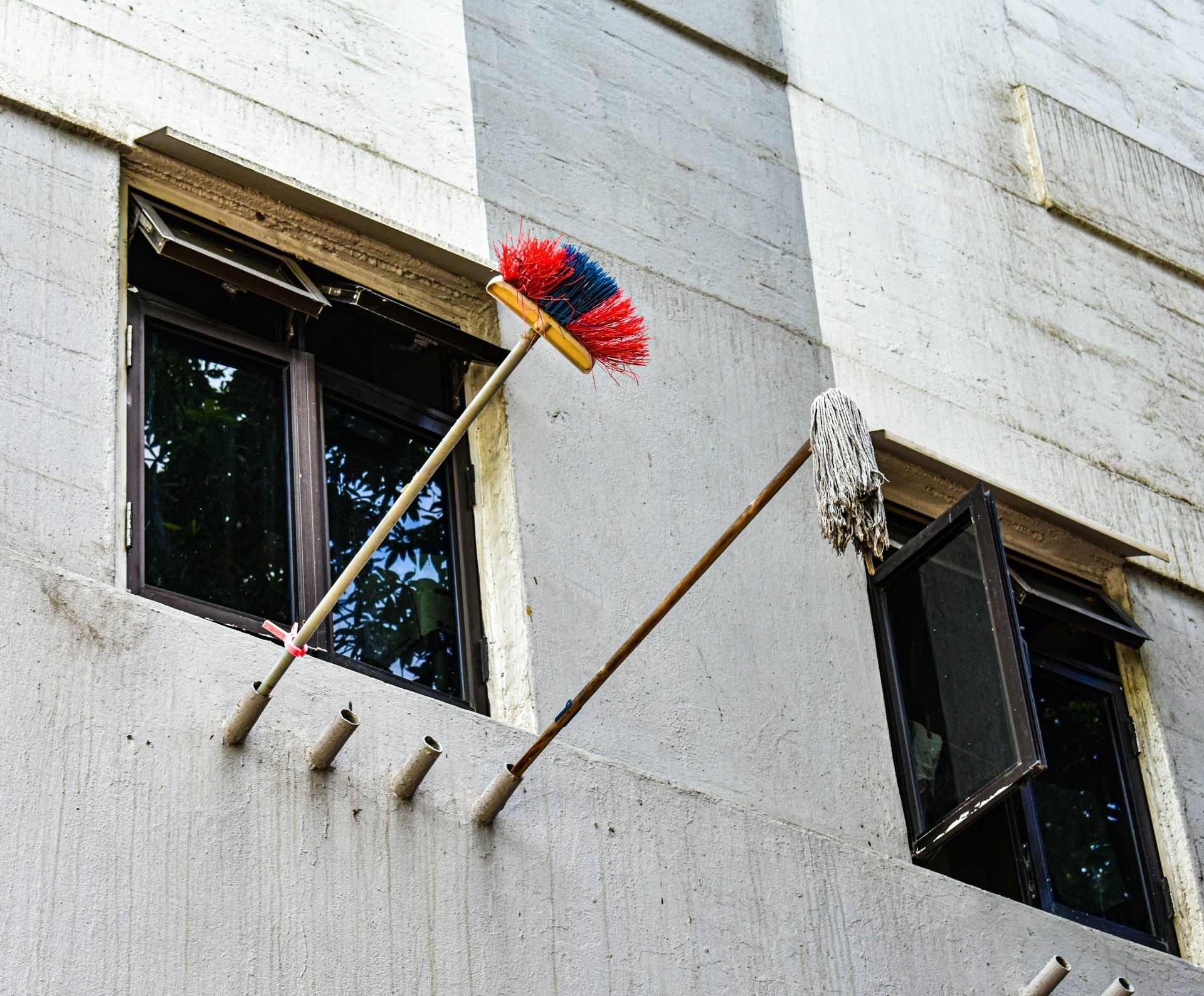 Nettoyage des fenêtres extérieures du bâtiment à l'aide d'un balai et d'une serpillière